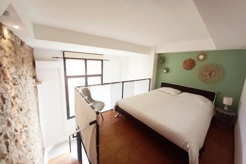une chambre avec un lit blanc et un mur vert dans l'établissement 35m2, luminous loft close to the beach, à Villefranche-sur-Mer