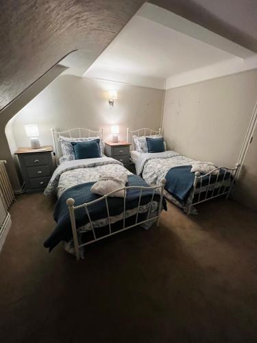 a bedroom with two beds in a attic at A La Maison - hébergement de luxe in Domfront