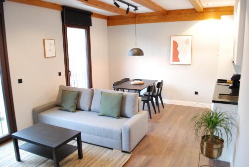 a living room with a couch and a table at Altar Suites Caño Badillo by gaiarooms in León