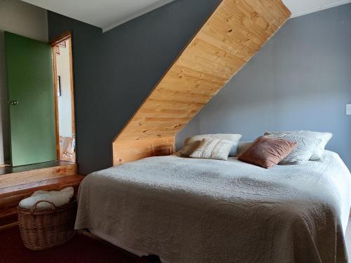 Cabaña familiar frutilar في Casma: غرفة نوم بسرير وسقف خشبي