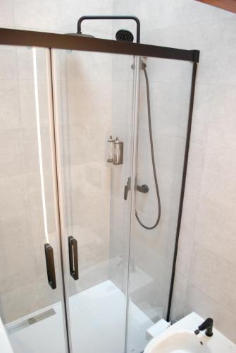 a shower in a bathroom with a toilet and a sink at Altar Suites Caño Badillo by gaiarooms in León