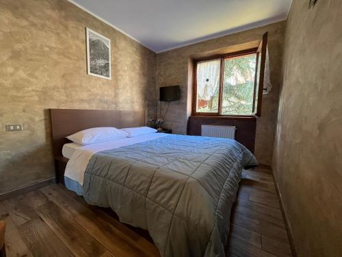 a bedroom with a bed and a window at San Luigi - Rooms & Apartments in Campodolcino