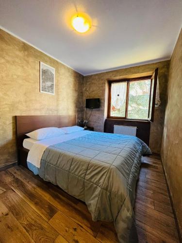 a bedroom with a bed and a window at San Luigi - Rooms & Apartments in Campodolcino