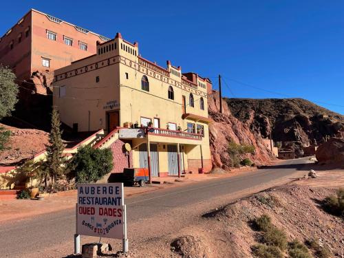 a building on the side of a road with a sign at Auberge oued dades in Boumalne