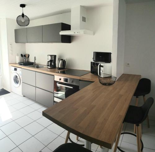 une cuisine avec une table en bois et des chaises. dans l'établissement Ile de Saint-Nicolas T2 et/ou Ile de Penfret Studio, à Fouesnant