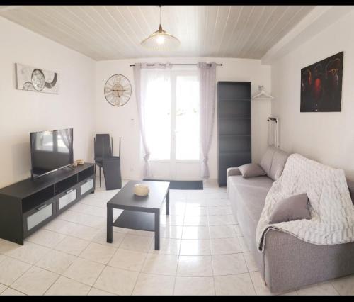 Ile de Saint-Nicolas T2 et/ou Ile de Penfret Studio في فوسنان: غرفة معيشة بها أريكة وطاولة