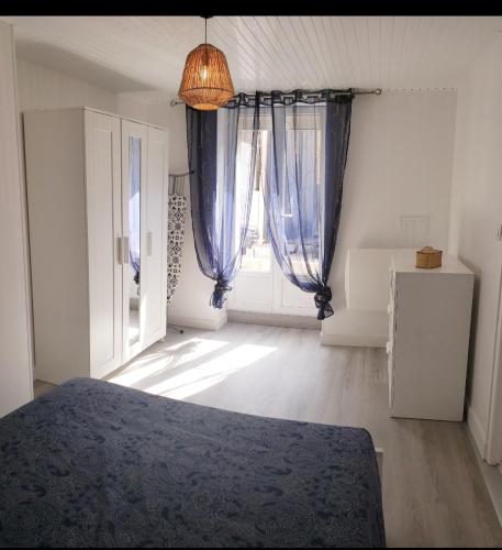 une chambre avec un lit et une grande fenêtre dans l'établissement Ile de Saint-Nicolas T2 et/ou Ile de Penfret Studio, à Fouesnant