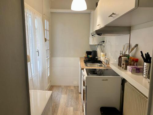 une petite cuisine avec un évier et une cuisinière dans l'établissement Park Avenue, à Orléans