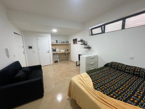 a bedroom with a bed and a couch in a room at Tia Nita Apartamentos in Mindelo