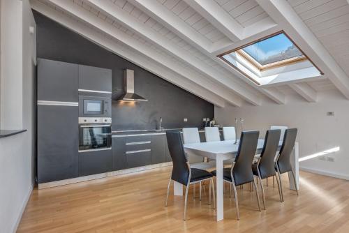 a kitchen and dining room with a table and chairs at [Duomo-Porta Torre] Penthouse with Private Terrace in Como