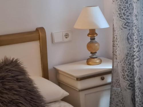 a lamp on a night stand next to a bed at 1930 Diecinueve Treinta "Diseño, historia y confort en el centro de Gijón" in Gijón