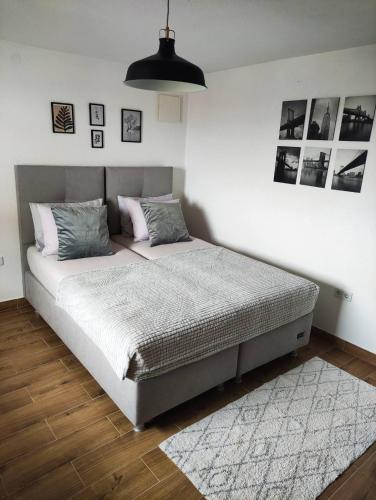 a bed in a bedroom with a white wall at Apartman Ela in Banja Luka