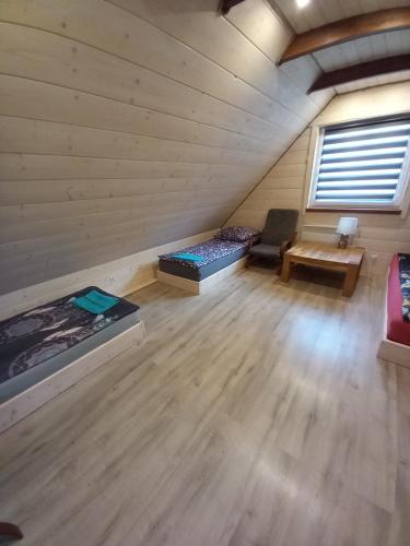 an attic room with two beds and a couch at Ostoja Spokoju in Sucha Rzeczka