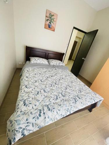 a bedroom with a bed with a blue and white comforter at 1 Bedroom Condo unit @ Iloilo Business Center in Iloilo City