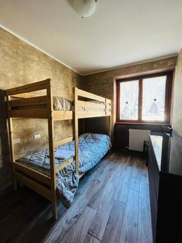two bunk beds in a room with wooden floors at San Luigi - Rooms & Apartments in Campodolcino