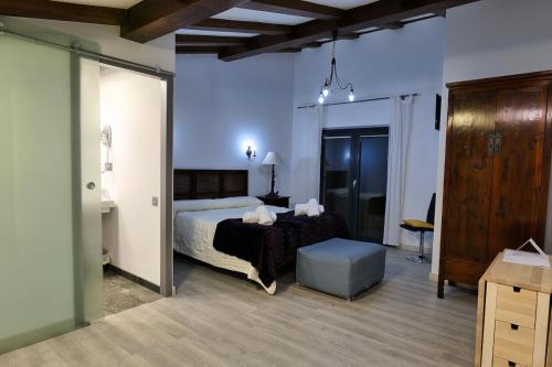 a bedroom with a bed and a table in a room at Hospederia Jaramillo in Peñaranda de Duero