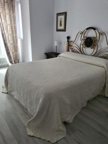 a bedroom with a bed with a white blanket at 1930 Diecinueve Treinta "Diseño, historia y confort en el centro de Gijón" in Gijón