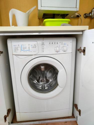 a washing machine in a kitchen with a microwave at "Appartamento del Mare Gliaca" con vista Isole Eolie,ampia terrazza,wifi e parcheggio gratuito in Piraino