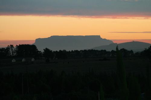 a sunset with the table mountain in the background at Hawksmoor House in Stellenbosch