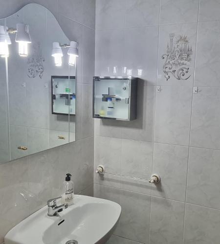 a white bathroom with a sink and a mirror at Apartamento Plasencia in Plasencia