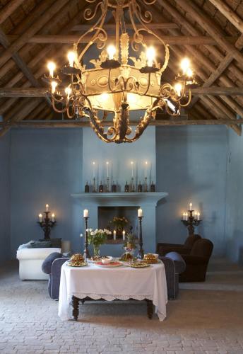 a chandelier in a room with a table and a fireplace at Hawksmoor House in Stellenbosch