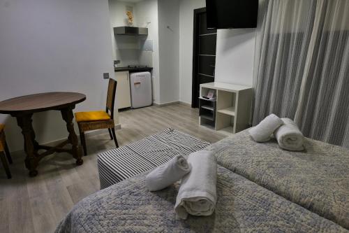 a hotel room with two beds and a table and a desk at La Sinagoga in Peñaranda de Duero