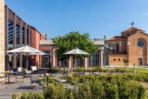 a courtyard with tables and umbrellas in front of a building at JW Marriott Venice Resort & Spa in Venice