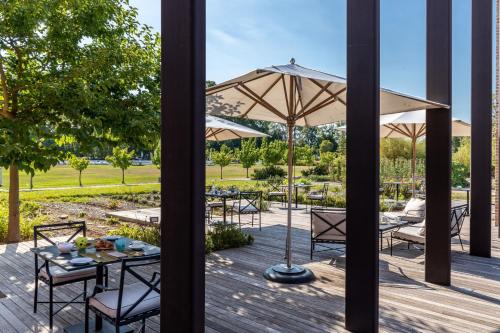 a deck with tables and chairs and an umbrella at JW Marriott Venice Resort & Spa in Venice