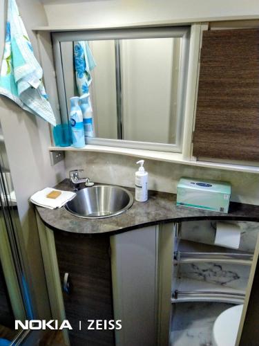 ガネダにあるRV Caravan in Rural Setting on Edge of Town close to AgQuipの洗面台と鏡を備えたバスルームのカウンター