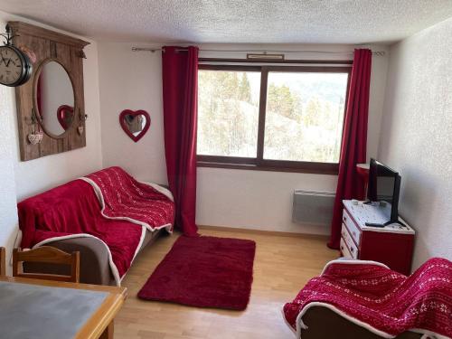 a living room with red curtains and a window at SUPER SAUZE Studio pied des pistes in Enchastrayes