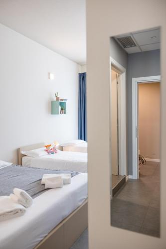 two beds in a room with a mirror at Casa a Colori Padova in Padova