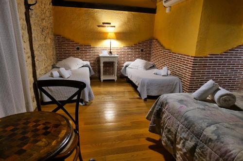 a room with two beds and a brick wall at La Sinagoga in Peñaranda de Duero