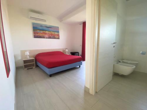 a bedroom with a red bed and a bath tub at Crystal B&B in Dormelletto