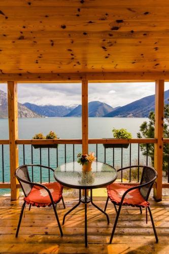 a table and chairs on a porch with a view of the water at Villa Strp in Risan