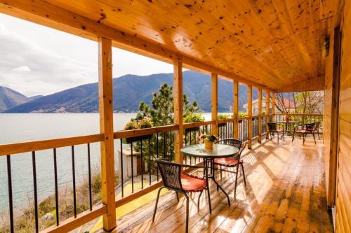 a porch with tables and chairs and a view of the water at Villa Strp in Risan