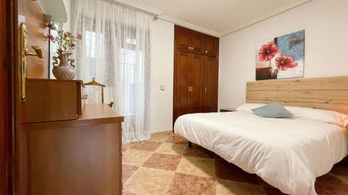 um quarto com uma cama, uma cómoda e uma televisão em CÓMODO alojamiento en Alba de Tormes em Alba de Tormes