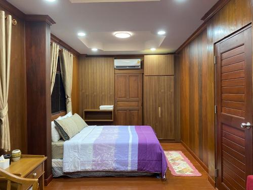 a small bedroom with a bed and a table at 188 Teak House บ้านต้นสัก in Chiang Mai