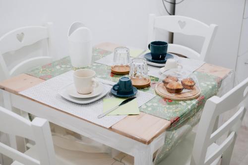 a table with a table cloth with cups and plates of food at Bed and Breakfest Terra d'Arneo in Leverano