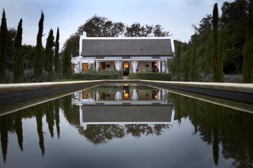 a house with its reflection in the water at Hawksmoor House in Stellenbosch