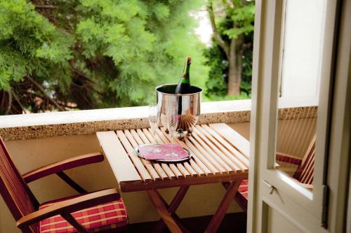 a wine bottle in a bucket on a table on a balcony at Ringhotel Bömers Mosel Landhotel in Alf