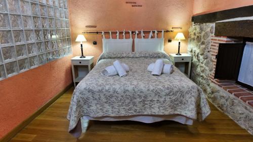 a bedroom with a bed with pillows and a fireplace at La Sinagoga in Peñaranda de Duero