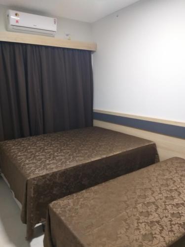 two beds in a room with a heater at Casa de Praia, pé na areia Guaratiba Prado - Bahia in Prado