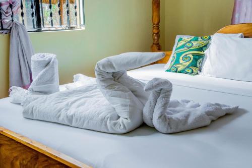 una cama con dos cisnes hechos de toallas en The Better Inn, en Moshi