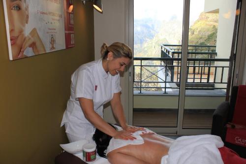 a woman giving a patient a massage in a room at Eira do Serrado - Hotel & Spa in Curral das Freiras