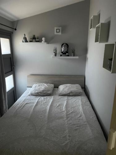 een slaapkamer met een bed met 2 kussens erop bij La Bergerie Furiani avec piscine privée Residence Digoune in Furiani