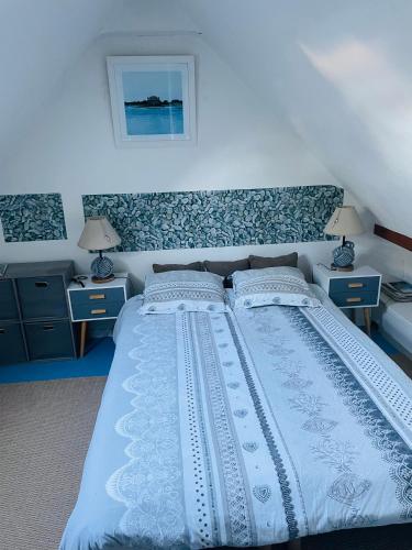une chambre avec un grand lit blanc avec deux tables de nuit dans l'établissement Appartement duplex hyper bien placé plages à 2 pas Carnac plage, à Carnac