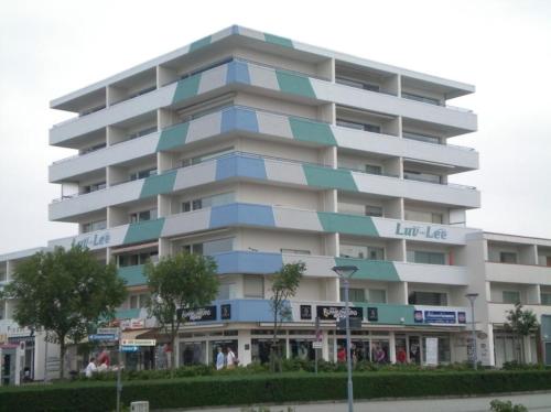 ein großes weißes Gebäude mit blauen Balkonen in der Unterkunft SPO - gemütliches Apartment - TOP LAGE in Sankt Peter-Ording