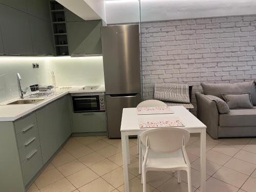 NAFPAKTOS-luxury suite في نافباكتوس: مطبخ مع طاولة وكراسي وأريكة