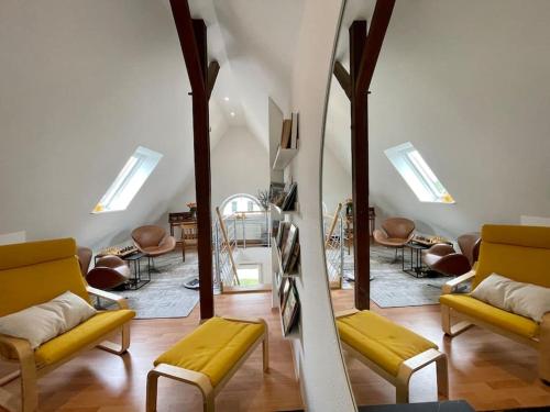 sala de estar con sillas amarillas y espejo en Modernes, familienfreundliches Apartment in Lübeck, en Lübeck