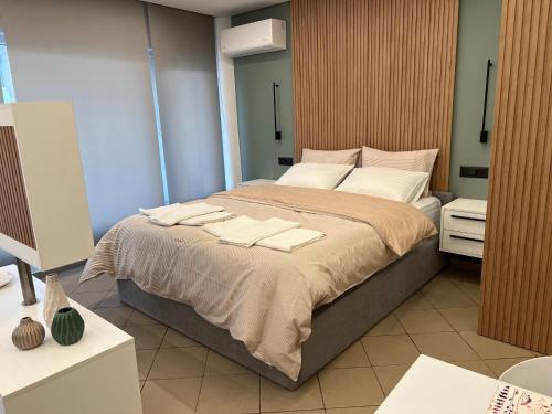 NAFPAKTOS-luxury suite في نافباكتوس: غرفة نوم بسرير كبير عليها مناشف